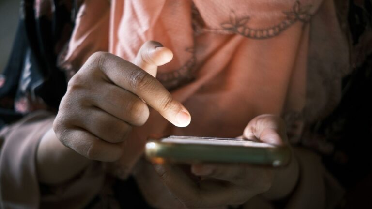 Person scrolling through a smartphone, representing feed-based information access